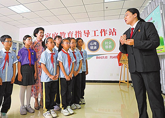 图为全国人大代表买世蕊（左三）听取“青果”家庭教育指导站保护未成年人权益相关情况。王魁子 摄