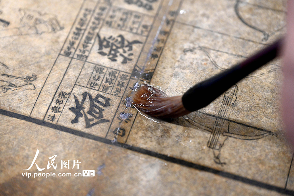 在河南省洛阳市图书馆古籍书库，工作人员对破损古籍进行修复。