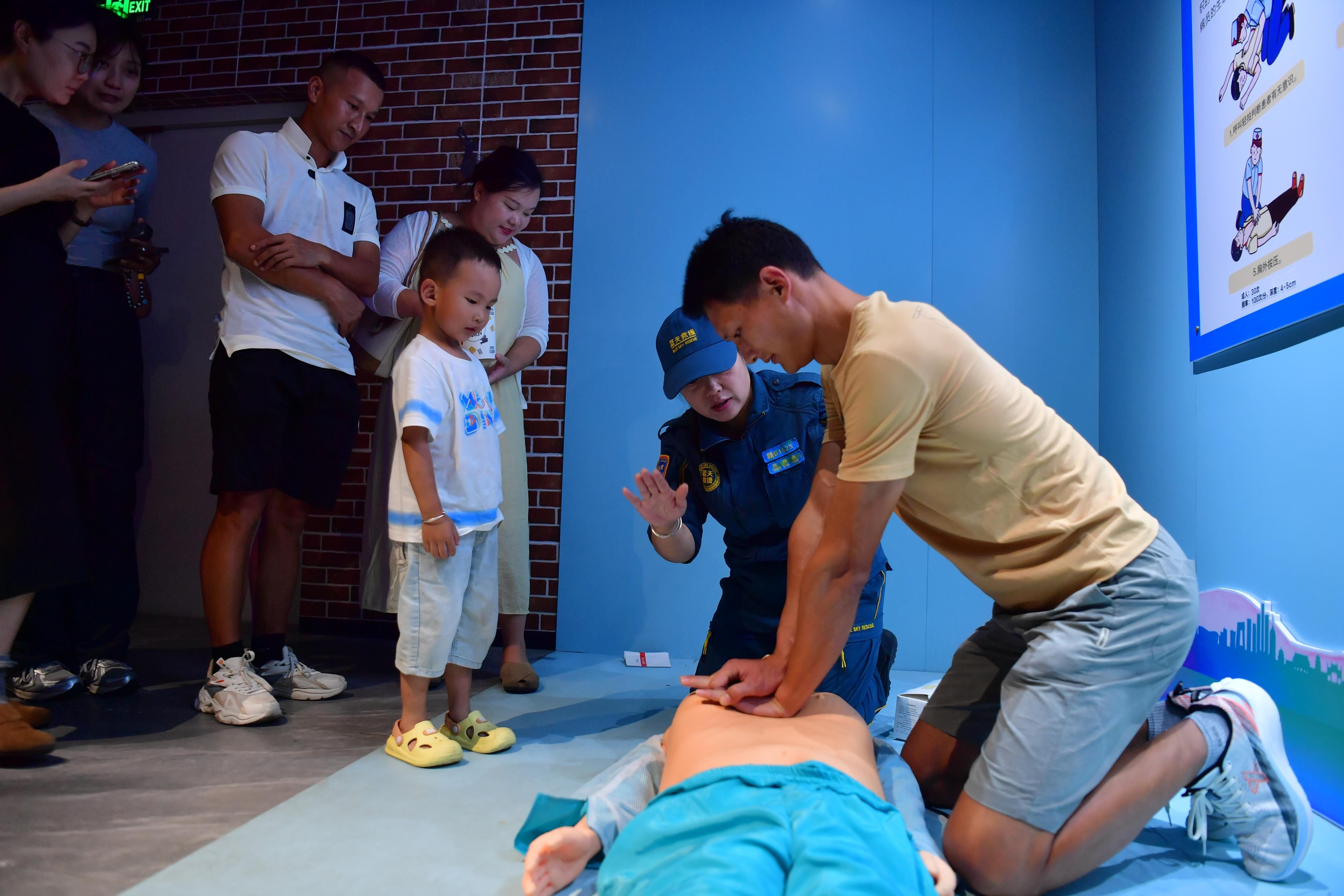 在赣州市赣县区安全文化主题影院内，救援队志愿者正在指导市民正确的心肺复苏方法。 人民网记者 时雨摄