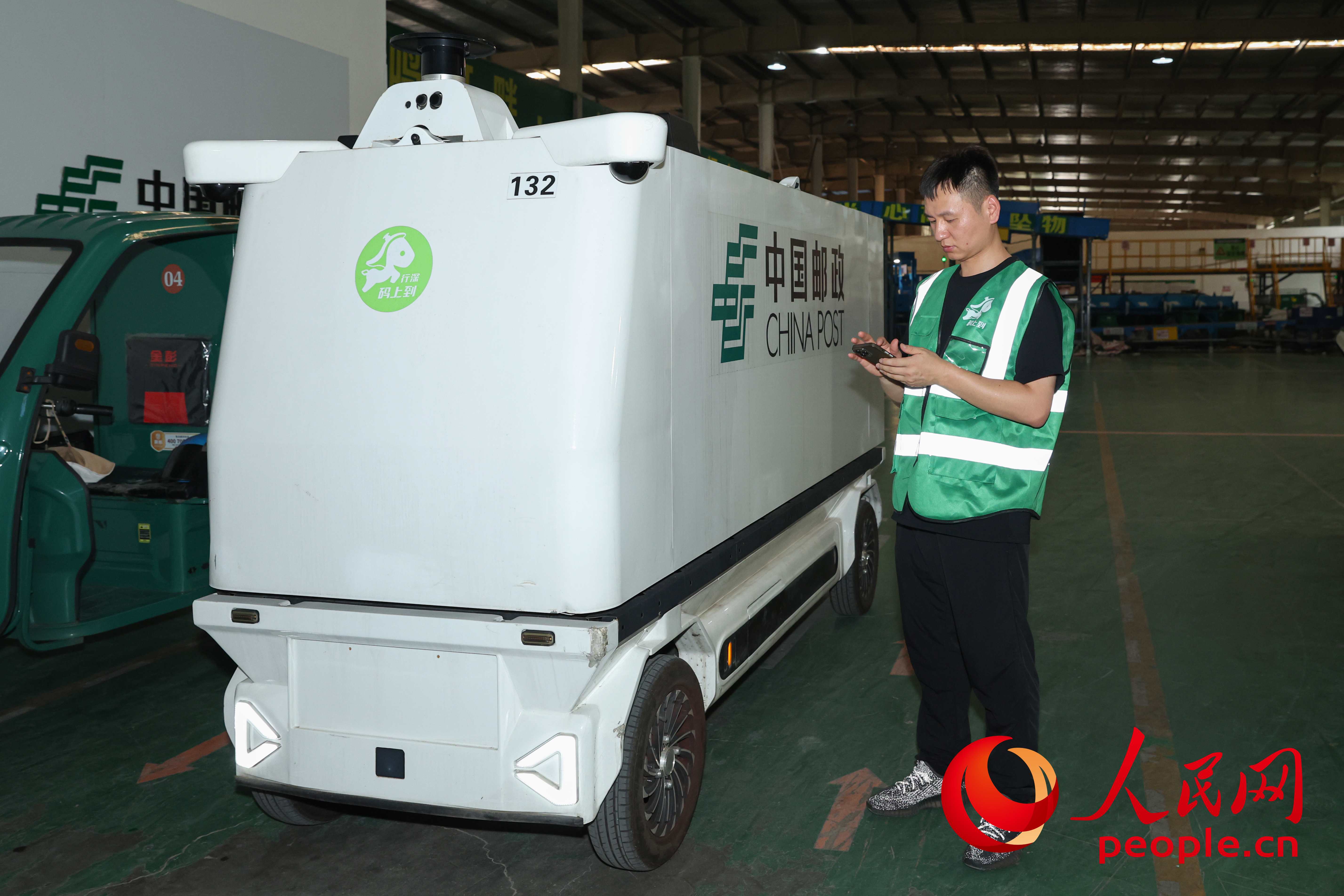 耿杰在调度无人快递物流车。人民网记者 张俊摄