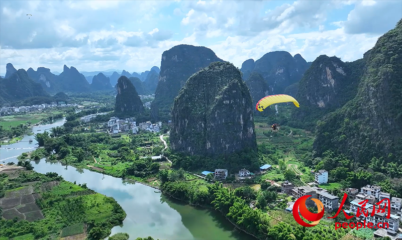 游客乘坐动力滑翔伞看阳朔的山水美景。人民网记者 严立政摄