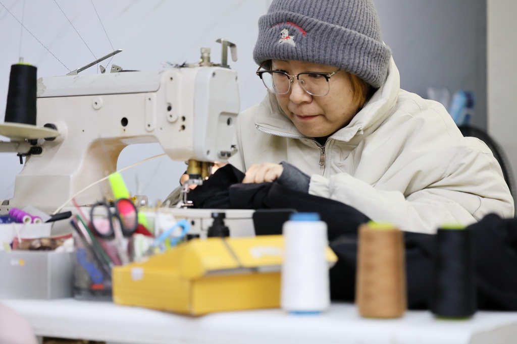 12月9日，商户在修补衣服。新华社记者 李然 摄