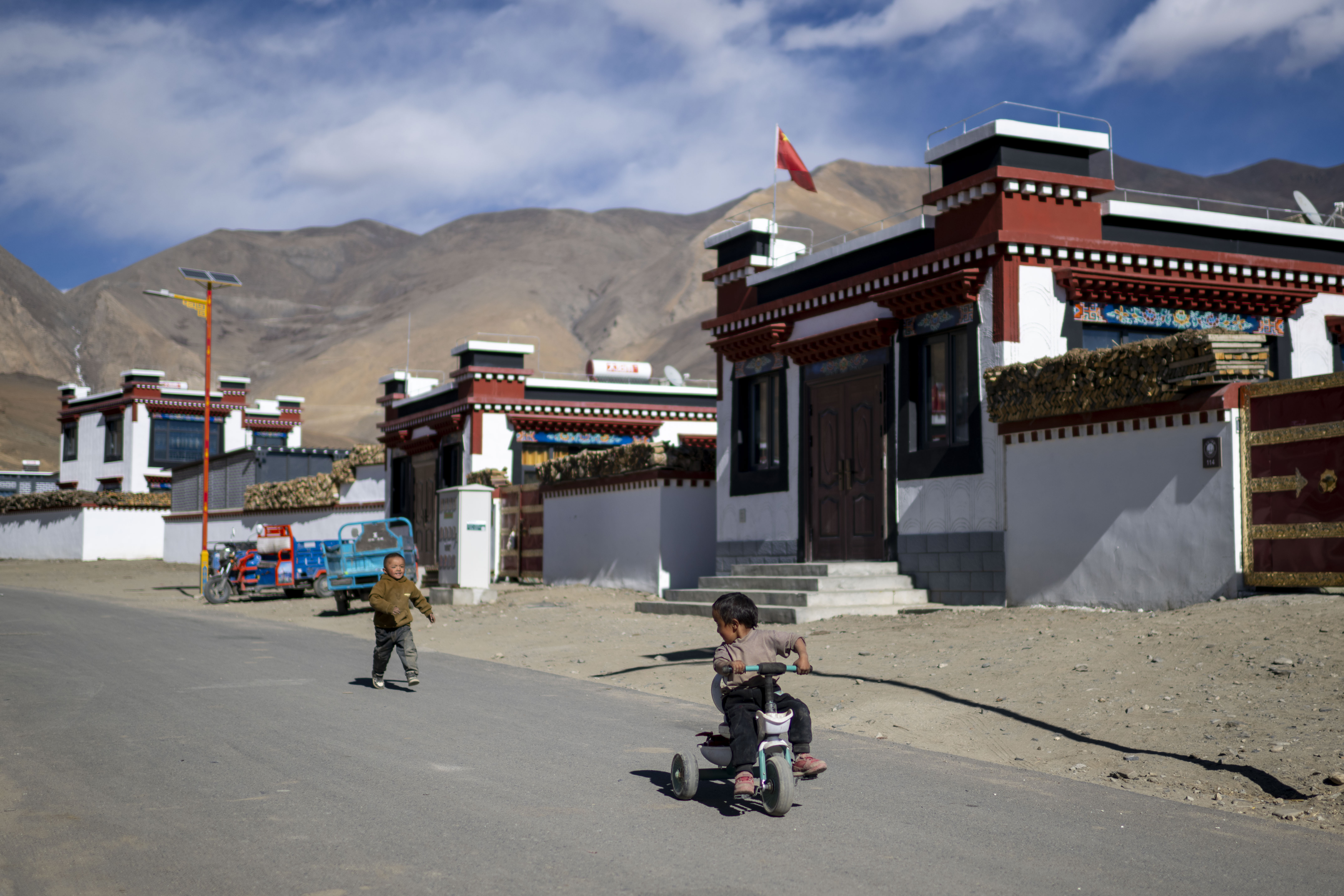 2025年12月11日,在西藏定日县长所乡森嘎村,小朋友们在整洁的村道上玩耍。人民网记者 翁奇羽摄