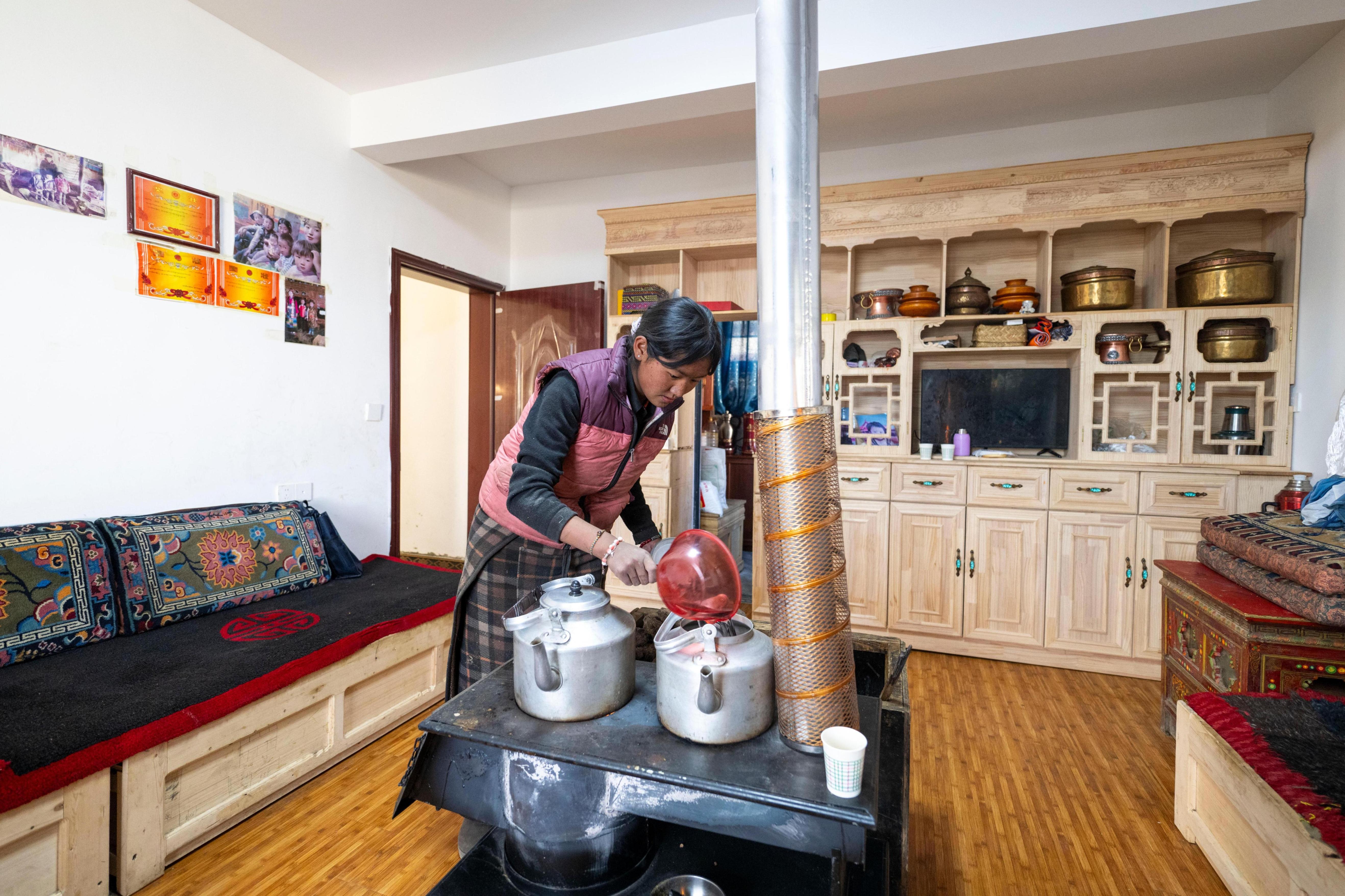 2025年12月11日,西藏定日县长所乡古荣村,村民次仁普尺在新家烧开水。人民网记者 翁奇羽摄