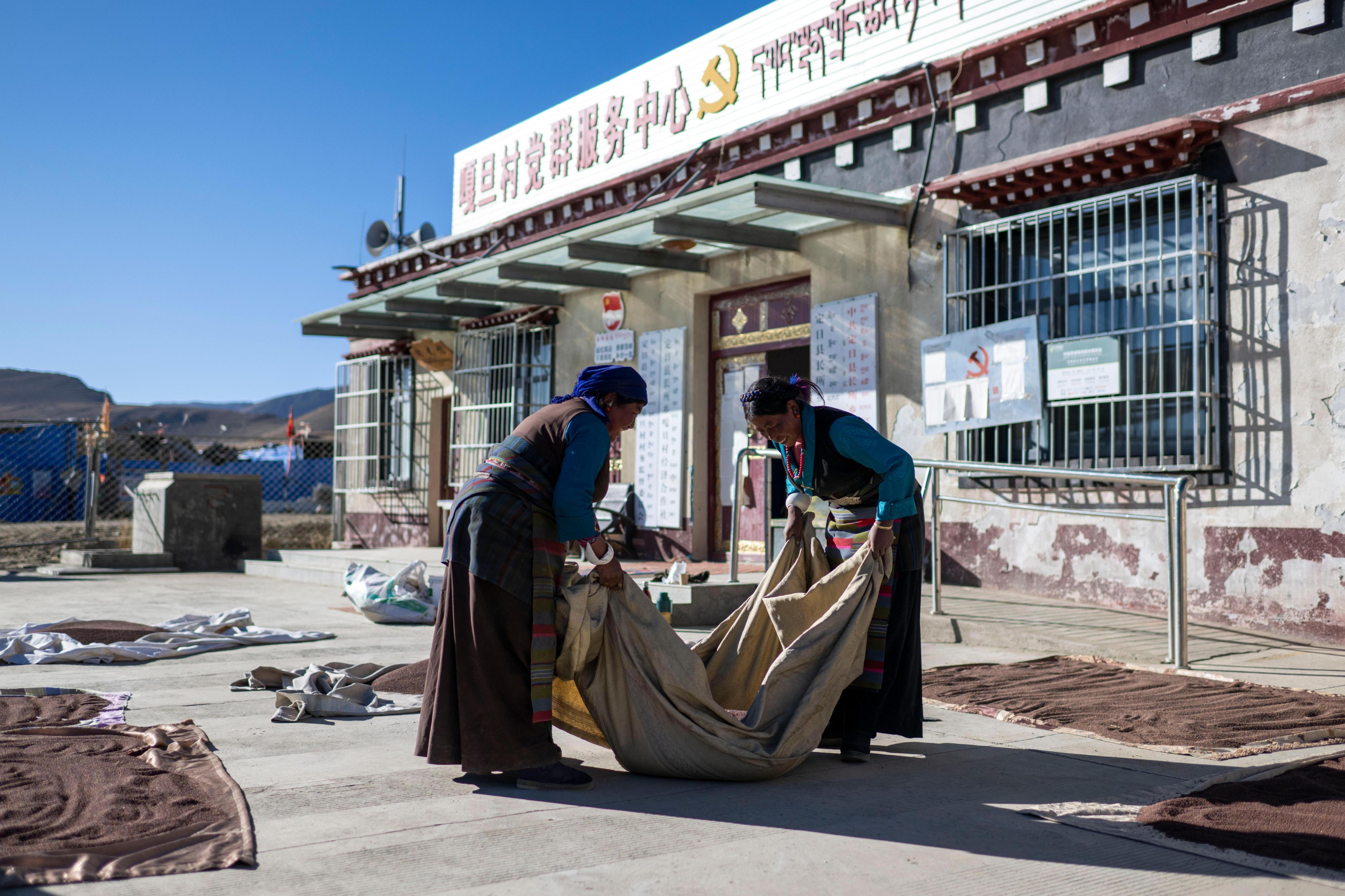 2025年12月13日,在西藏定日县长所乡嘎旦村党群服务中心,村民正在晒菜籽。人民网记者 翁奇羽摄