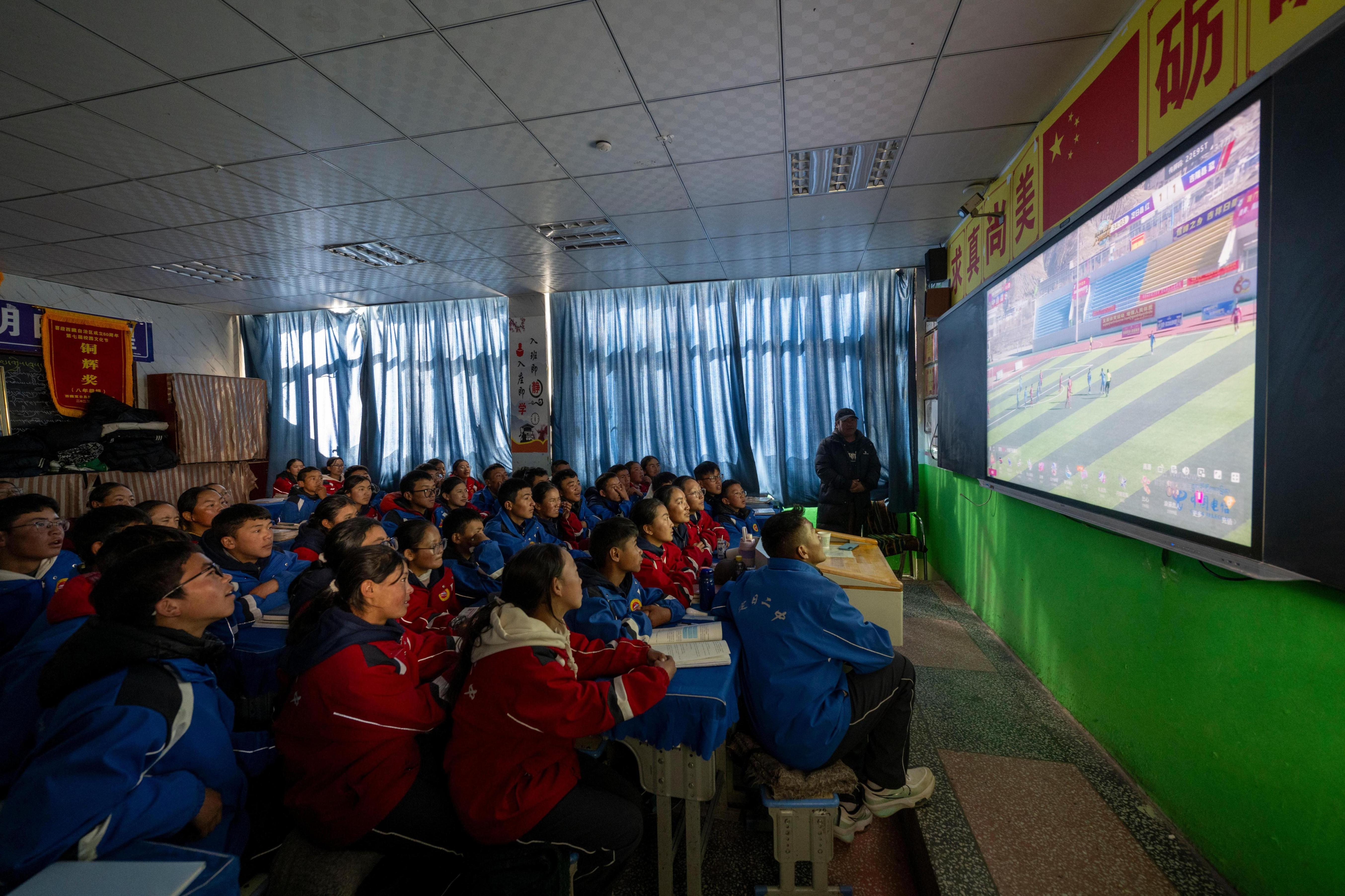 2025年12月12日,在西藏定日县第二初级中学,学生们正在观看日喀则市第十二届“体彩杯”足球赛定日县对阵吉隆县的比赛实况。人民网记者 翁奇羽摄