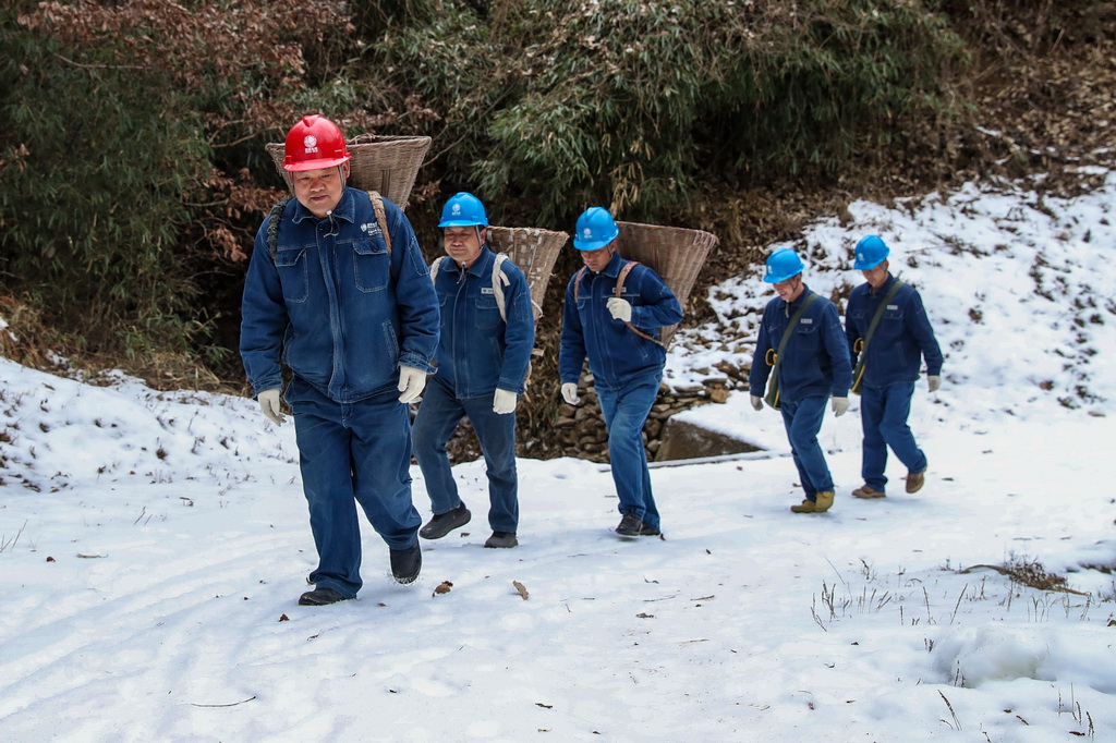 1月18日，在甘肃省陇南市两当县泰山乡，杨店供电所职工踏雪巡检供电线路（无人机照片）。