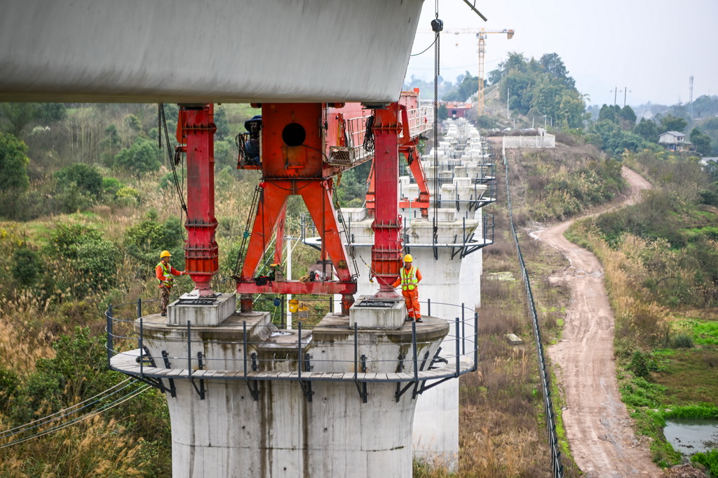 2月26日，在重庆市合川区清平镇的西渝高铁建设工地，工人在进行架梁作业。