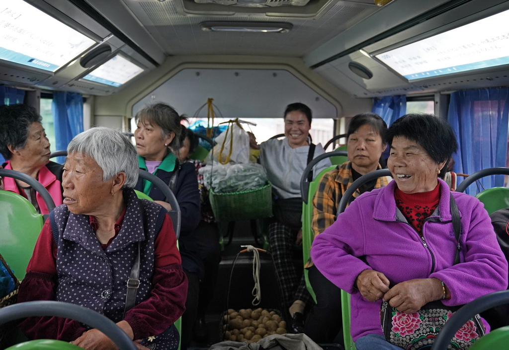 在“菜农专线”公交车上，菜农们闲聊家常（5月9日摄）。