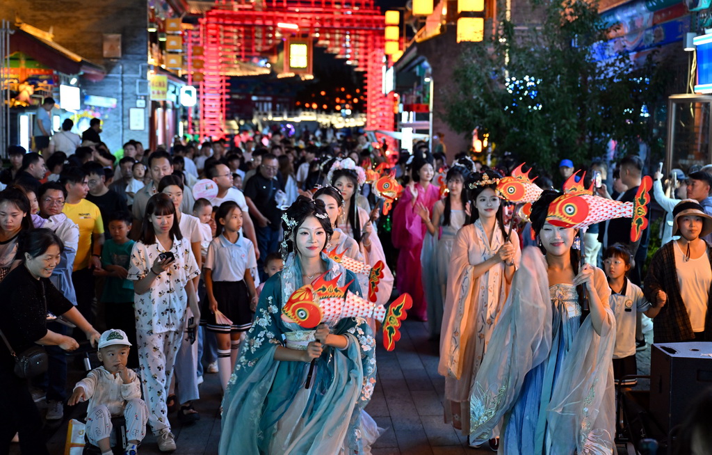 6月5日，游客在京杭大运河沧州段沿线的南川老街观看巡游表演。新华社记者 郭程 摄