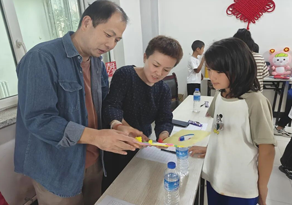 孙凯（左）与董坤岳（中）在轮台县第四中学与学生交流。 图片来源：巴州零距离