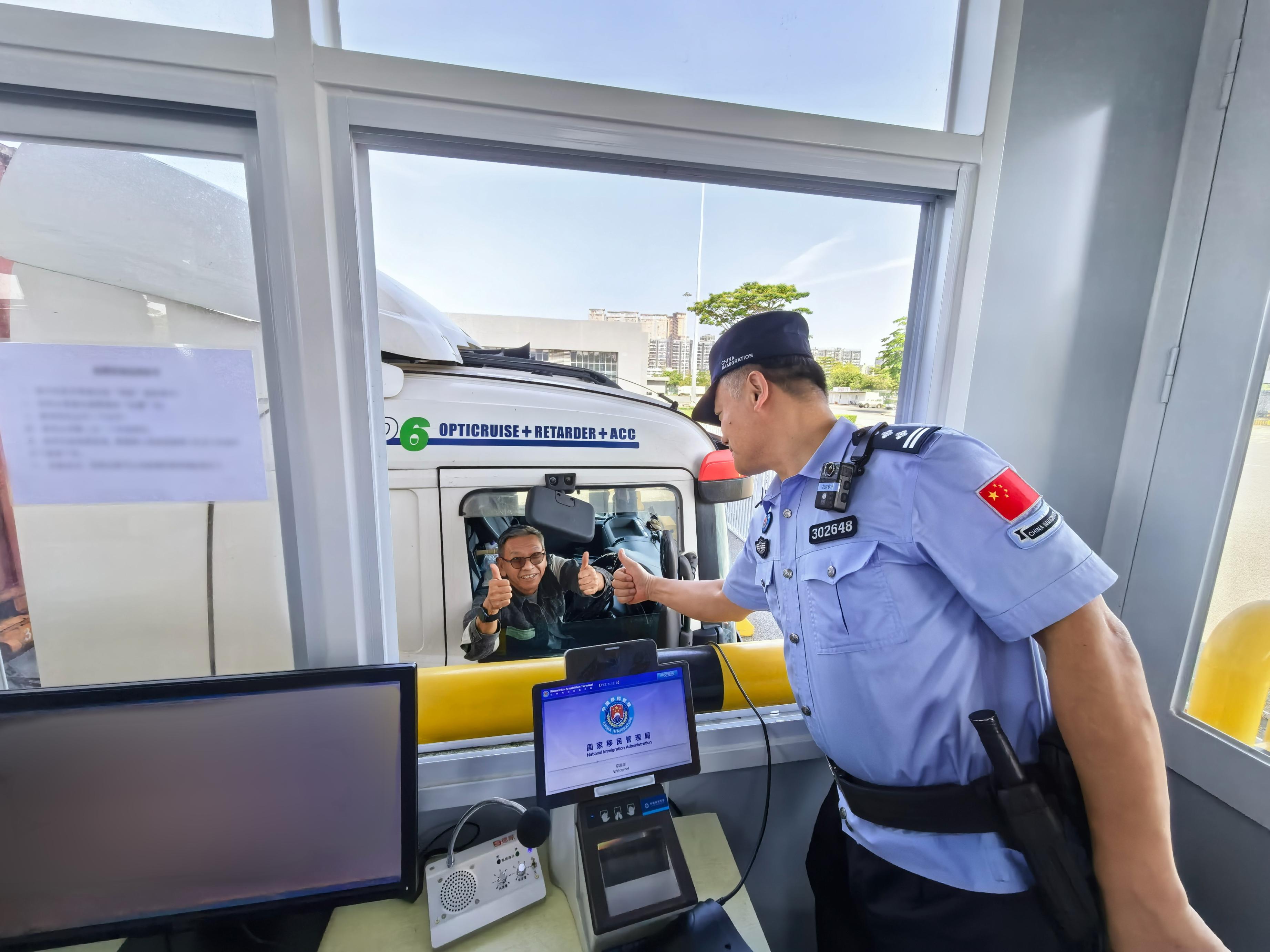 深圳湾边检站移民管理警察为跨境货车司机进行“刷脸”智能快捷通道信息采集。深圳边检总站供图