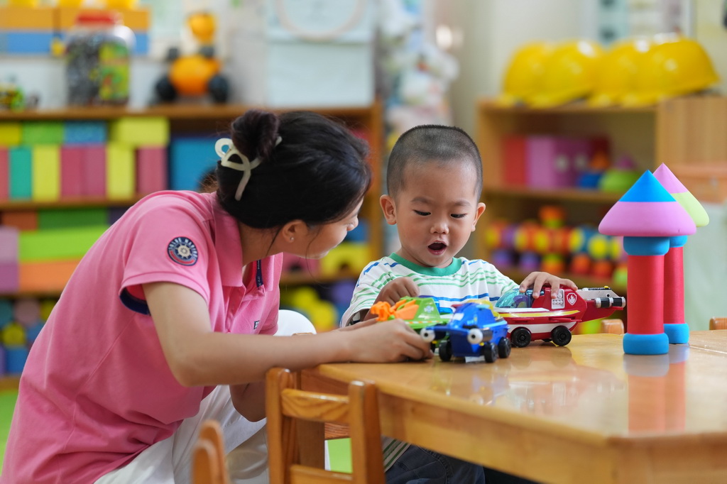 9月2日，在北京九龙幼儿园，一名幼儿在老师的陪伴下度过入园适应期。